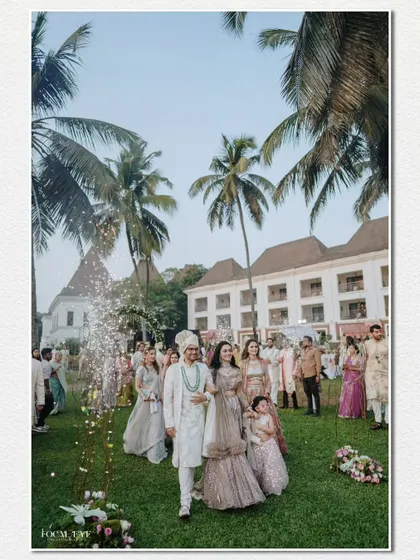 The groom makes his grand entrance with his family, set against the backdrop of a beautiful Goa resort with its iconic palm trees.