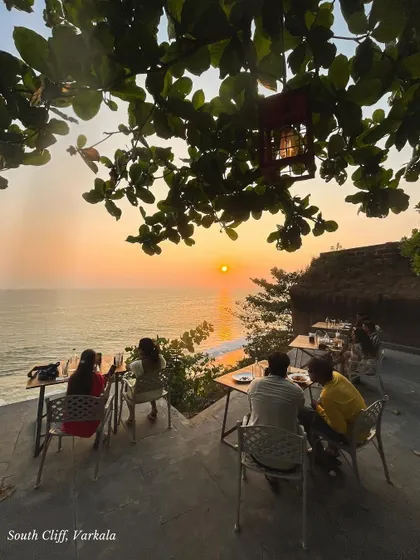 A quiet moment at a cliffside cafe in Varkala, watching the sun dip below the horizon. Our Kerala trips are filled with these peaceful, unforgettable moments.