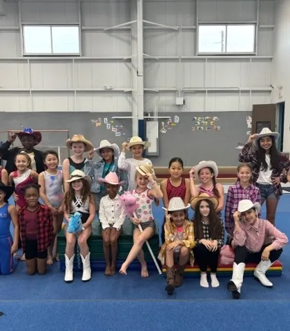 The whole rodeo crew! A group of our young athletes dressed in cowboy hats and boots for a fun, themed practice day.