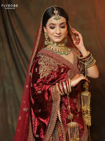 A close-up on the luxurious velvet shawl and the detailed embroidery of the blouse. Every element of this bridal lehenga is crafted to perfection.