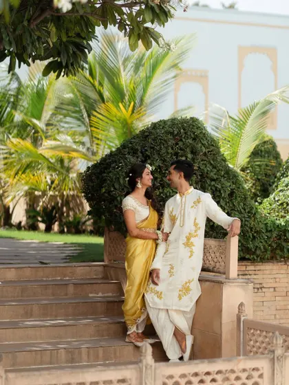 The couple posing on the steps of the beautiful Radisson Blu Udaipur. The venue's architecture provides a stunning backdrop for pre-wedding photos.
