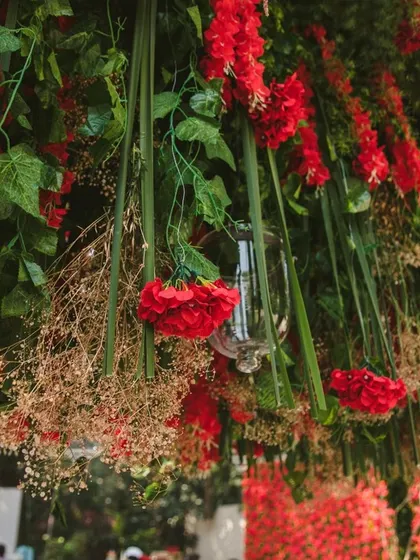 An artistic close-up of the hanging red floral installation, highlighting the different textures of flowers and foliage used to create this stunning effect.