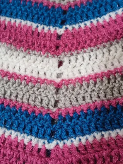 A macro shot of the stitchwork on my semi-circle shawl. The simple stitches create bold stripes of fuschia, grey, blue, and white, forming a clean and modern design.