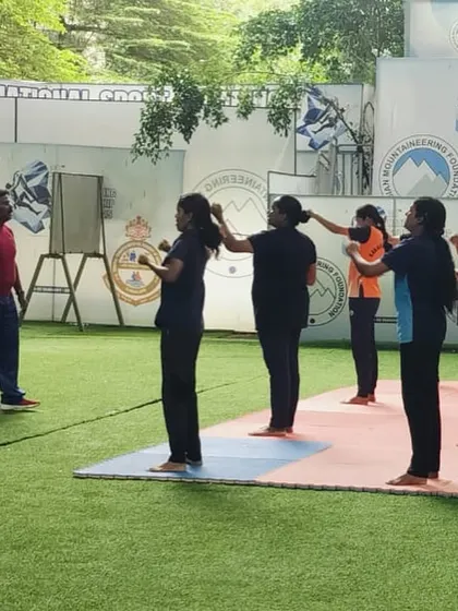 An instructor demonstrates a blocking technique to a small group. This focused training ensures each participant understands the mechanics of defending against strikes before practicing with a partner.