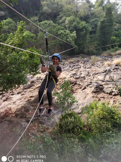 Another happy camper enjoying the zipline over a rocky riverbed.