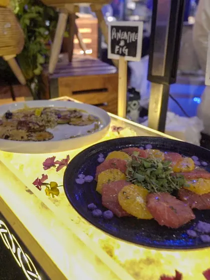 A colourful display of our pineapple and fig carpaccio, presented on a backlit, glowing surface. We use creative lighting and presentation techniques to make our food stations stand out.