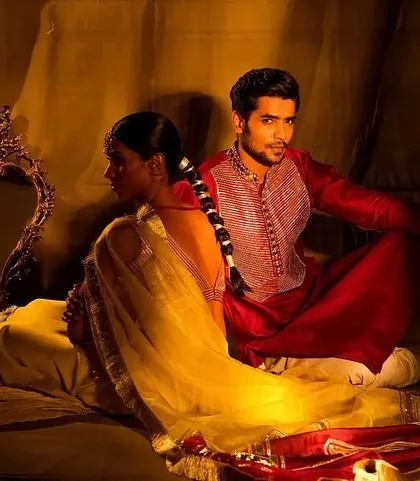 A dramatic, artistic shot for the Nayantaara campaign. The makeup is warm and bronzed, creating a painterly effect that complements the rich, traditional setting.