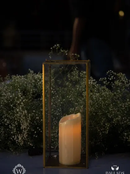 The outdoor lounge area for a reception, illuminated by fairy lights and candles. The elegant white furniture and surrounding greenery created a cozy and romantic space for guests to relax.