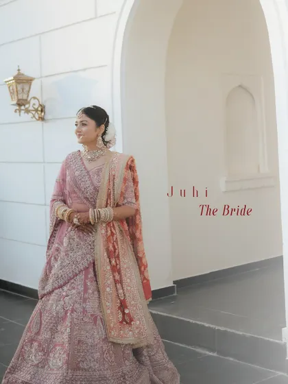 A full-length portrait of the bride, her pastel lehenga perfectly complemented by the soft, natural light and the elegant architecture.