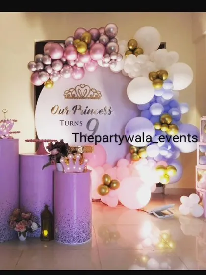 A princess-themed ring decoration with purple, pink, and gold balloons.
