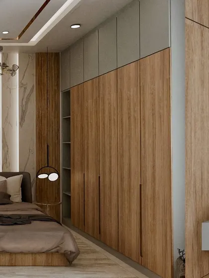 A view of the seamless floor-to-ceiling wardrobe, which provides ample storage while maintaining a clean, modern aesthetic. The mix of wood and light gray panels keeps the design interesting.