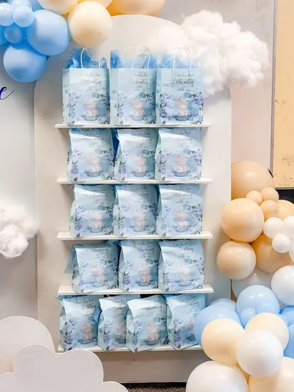 Custom-designed favor bags displayed on a dedicated shelf, perfectly integrated into the "Over the Moon" themed decor.