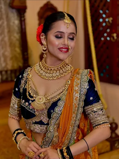 The smile of a happy bride is the best reward. This traditional Nauvari look is completed with classic gold jewellery and a radiant smile.