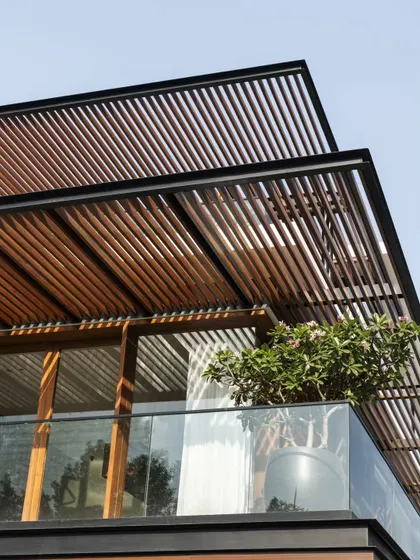 A close-up of the angled wooden pergolas at Villa re:FORM. This detail shows the craftsmanship and the way the structure is designed to filter sunlight.