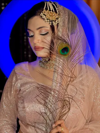 This look features a stunning white graphic liner, creating a modern and high-fashion feel. The peacock feather adds a touch of natural beauty to this artistic concept.
