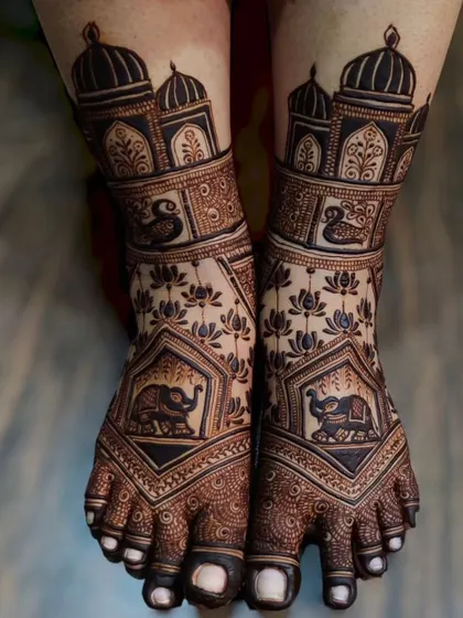 A royal-themed foot mehandi with elephant motifs inside ornate frames, complemented by lotus patterns and palace domes.