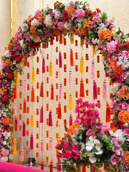 A detailed shot of the floral arch, showcasing the rich colors and textures of the flowers and tassels.