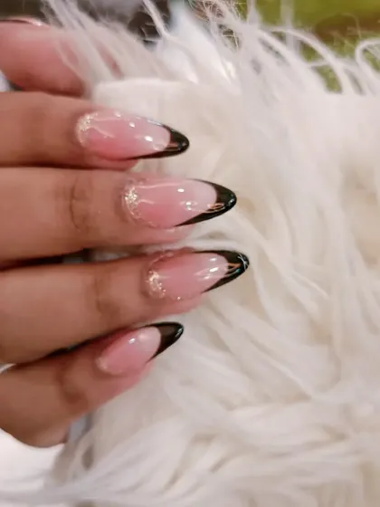 A close-up of the black French tip with a subtle gold glitter accent, a perfect example of minimalist luxury.