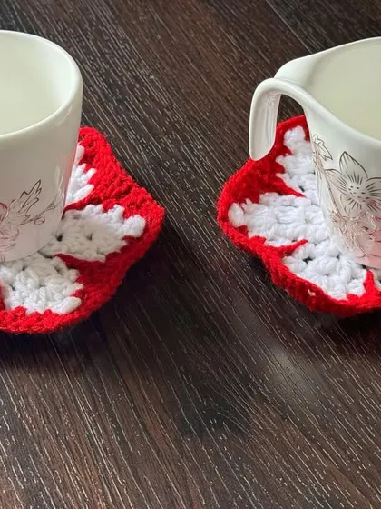 A pair of my snowflake-themed coasters in classic red and white. They are perfect for serving warm drinks during the cold Christmas season.