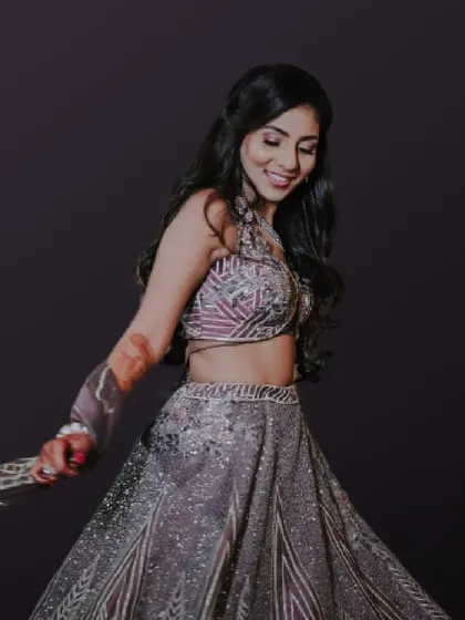 A beautiful shot of the bride twirling in her futuristic grey lehenga. The soft, open hairstyle and glowing makeup are perfect for a night of dancing.