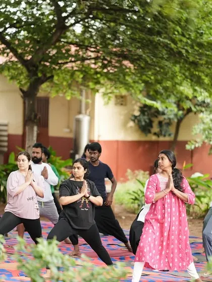 A group of participants in a warrior pose variation, building strength and focus together.