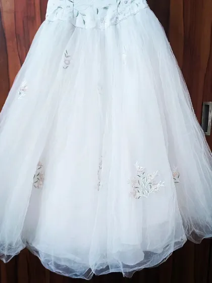 The full skirt of the embroidered white gown, showing how the tulle drapes beautifully. This is a romantic and unique rental option.