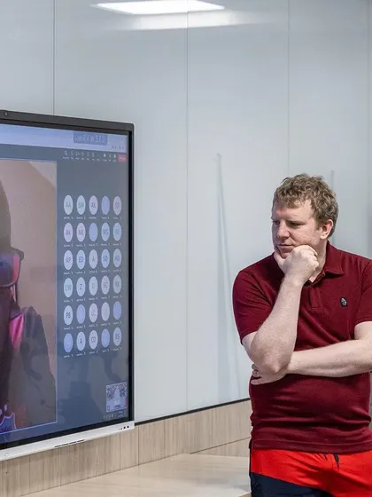 A UKSCA trainer listens to an online speaker's presentation, highlighting the global collaboration at our events.