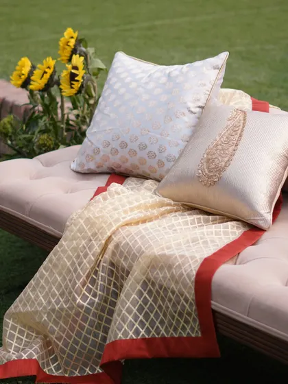 Elegant diwan seating with traditional brocade throws and cushions, perfect for a royal-themed Mehendi.