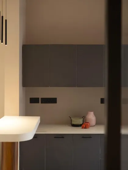 A view into the pantry from the side, highlighting the pendant lighting and the smooth transition between different functional zones.