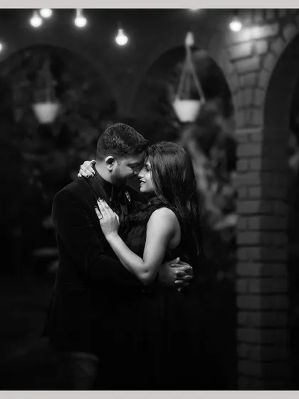 A timeless black and white portrait of the couple in a close embrace, their intimacy beautifully captured in the soft light.