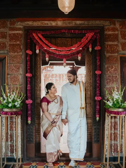 The couple makes their grand entrance through a beautifully decorated doorway, ready to begin their new life together.