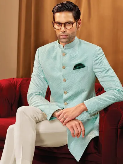 This subtle sherwani in a pastel hue speaks volumes with its clean lines and flawless fit. It is a piece we designed for the man who leads with quiet confidence and minimal elegance.