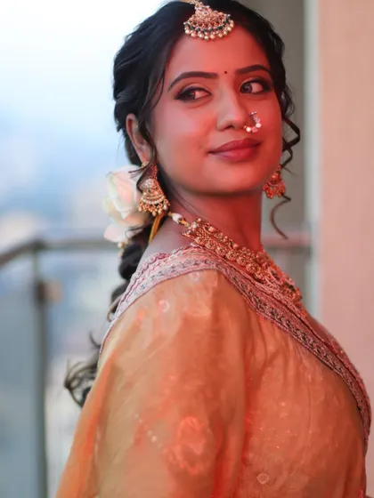 A candid glance. Her bridal makeup looks flawless from every angle, capturing the soft, golden hues of her outfit.