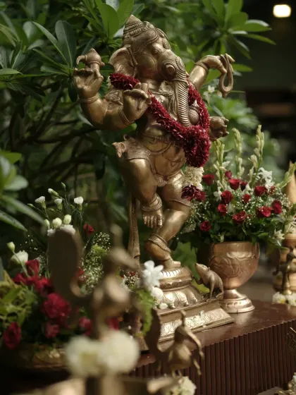 A dancing Ganesha idol, adorned with a red floral garland, placed prominently to bless the union. I always incorporate these sacred touches to honor our traditions.
