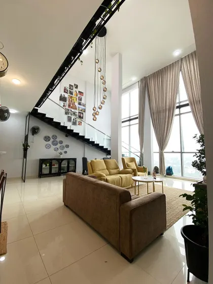 This wide shot captures the seamless flow between the living area, dining space, and staircase in the open-plan penthouse, demonstrating my approach to cohesive, multi-functional design.