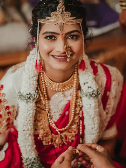 The sacred moment of tying the mangalsutra. This close-up captures the bride's serene expression and the significance of this Maharashtrian wedding ritual.