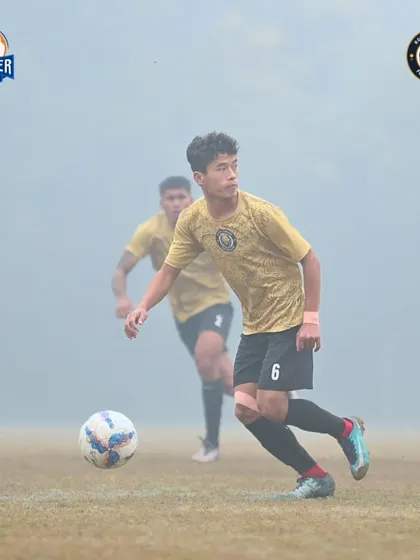 Eyes on the ball. A player advances with possession, looking for the perfect pass to unlock the defense.