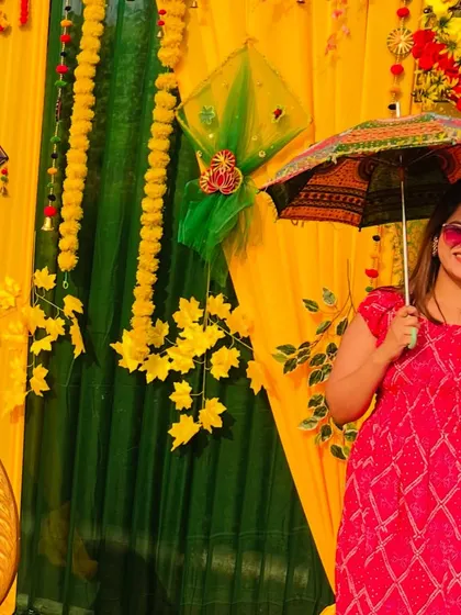 Having some fun with the props at a Haldi ceremony. The colourful umbrella adds to the festive feel.