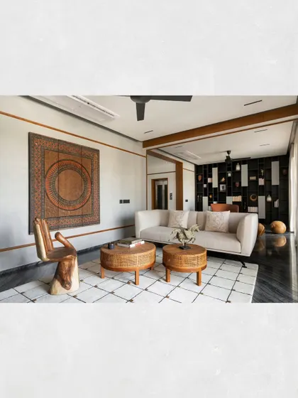 The guest lounge in Kamala Residence, featuring a unique hand-shaped wooden chair and a large, carved wall panel that add an artistic, sculptural quality to the space.