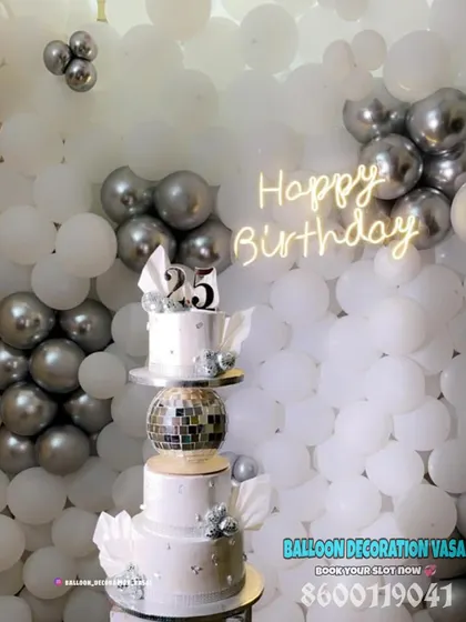 A close-up of a tiered cake for a 25th silver jubilee, set against a white and silver balloon wall. We can help coordinate cakes too.
