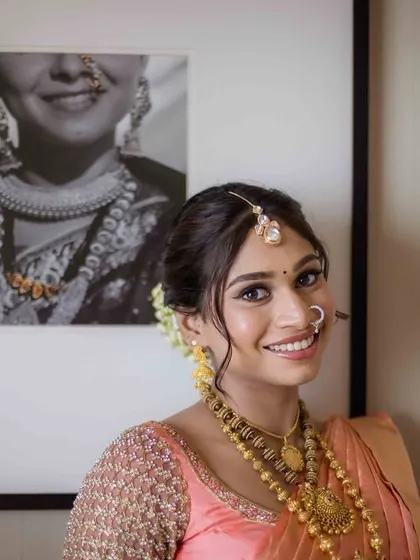 A happy bride posing next to a framed photo, perhaps of her mother or another inspiration. This adds a layer of personal story to the bridal portrait.
