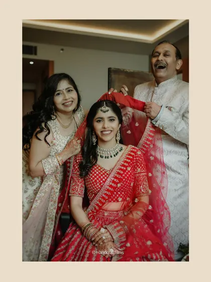 A heartwarming family moment as the bride's parents help her with her veil before the reception.