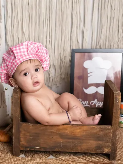 Our little chef on duty, looking so sweet in a rustic wooden crate. This theme is perfect for capturing those chubby baby rolls and curious expressions.