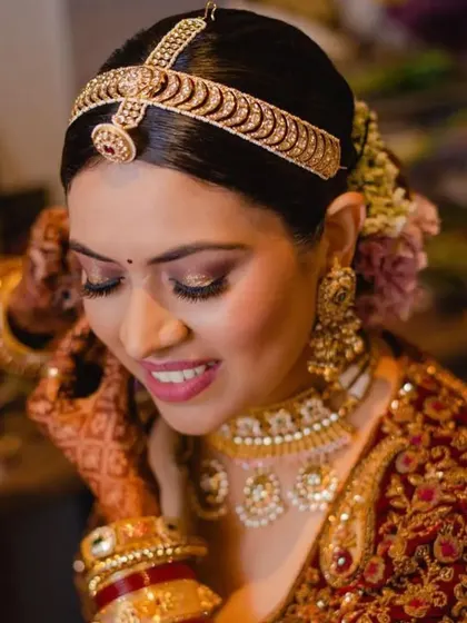 A smiling bride with a classic floral bun. The hairstyle is neat and allows her natural beauty and happiness to shine through.