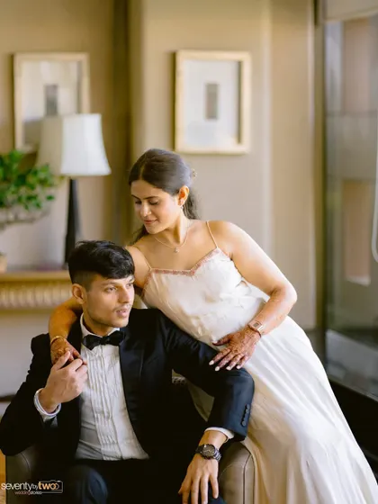 A stylish and intimate portrait of the couple, her arm around him, sharing a quiet moment of connection.
