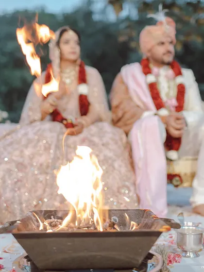 A close-up of the sacred fire during Neha and Tushar's ceremony. The soft, romantic lehengas of the couple were perfectly complemented by the blush and white floral decor, creating a warm and intimate atmosphere.