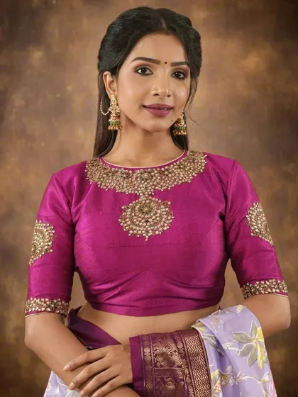 For a truly royal look, the model wears a heavily embellished blouse with a statement neckline. The matching oversized earrings complete the ensemble, making it perfect for a wedding.