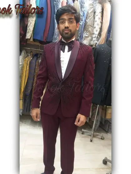A happy customer in our showroom trying on a maroon tuxedo with black embroidery. The fit is perfect right off the rack.