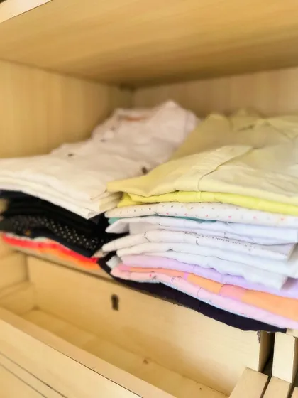 A simple stack of folded shirts. Even without complex organizers, proper folding and stacking can make a huge difference in keeping shelves tidy.