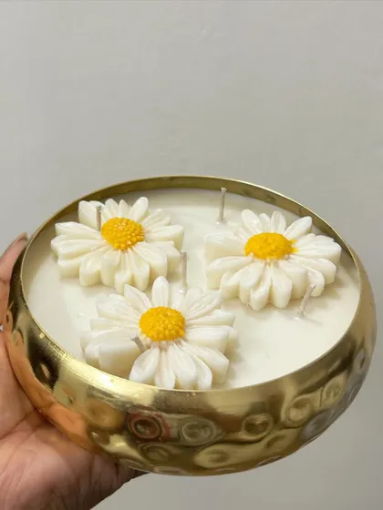 Another view of me holding the 6-inch daisy urli candle. It has 5 wicks for a bright and even burn.